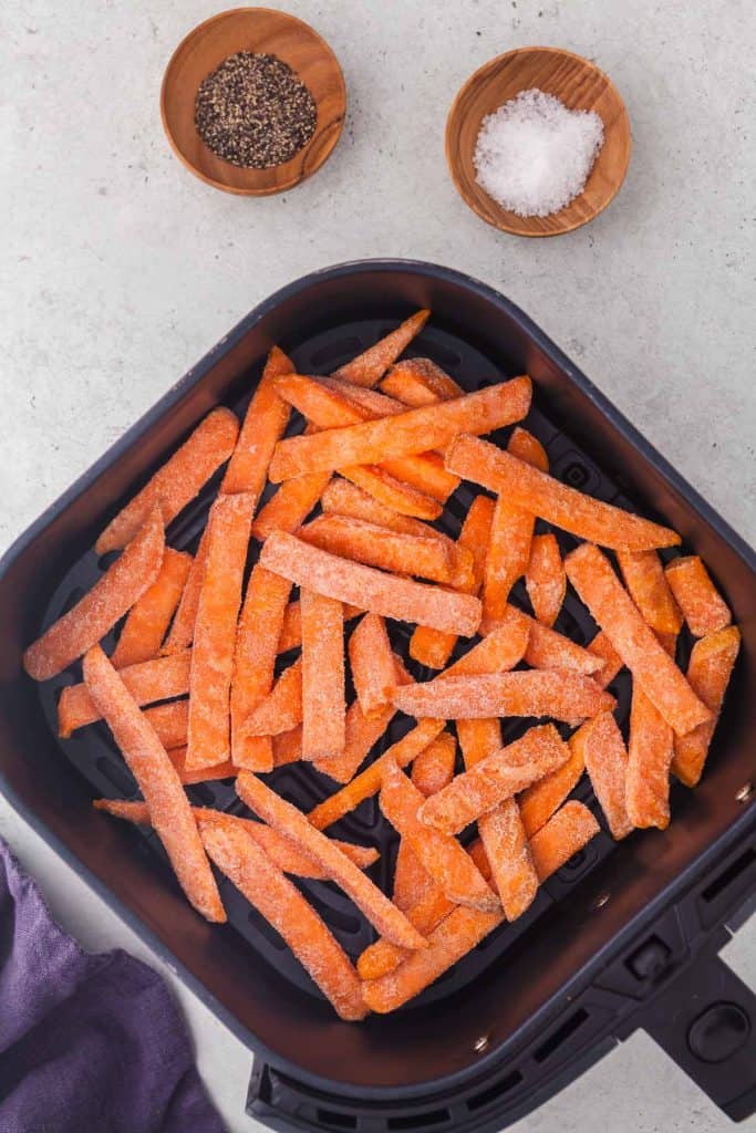 Frozen Sweet Potato fries in a single layer in the air fryer basket