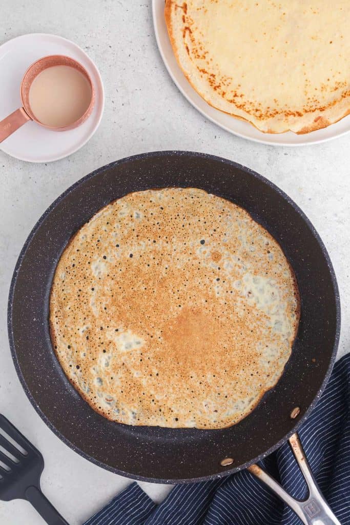 A crepe flipped over in the skillet - almost ready to serve