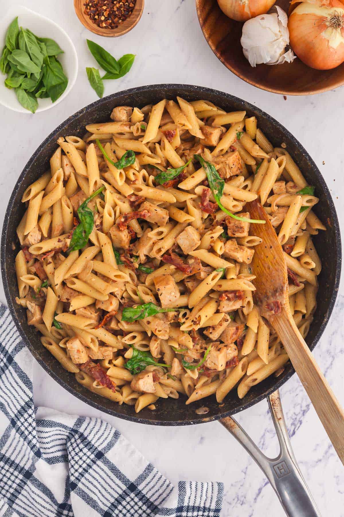 Overhead shot of a frypan filled with ready to serve Marry Me Chicken Pasta garnished with fresh basil.