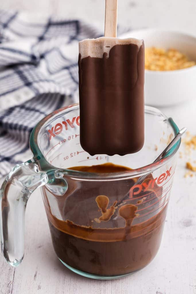 side view showing a banana popsicle which had just been dipped into the chocolate magic shell.