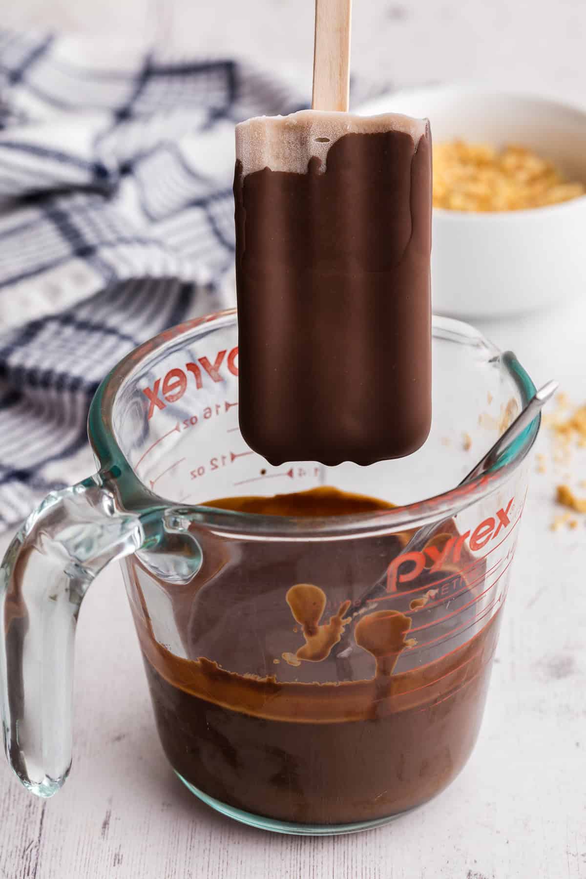 side view showing a banana popsicle which had just been dipped into the chocolate magic shell.