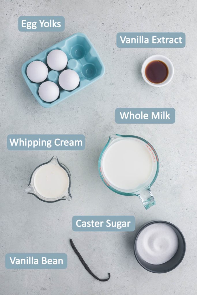 Overhead ingredient shot showing what is needed to make vanilla gelato: egg yolks, whole milk, cream, sugar, vanilla bean and caster sugar