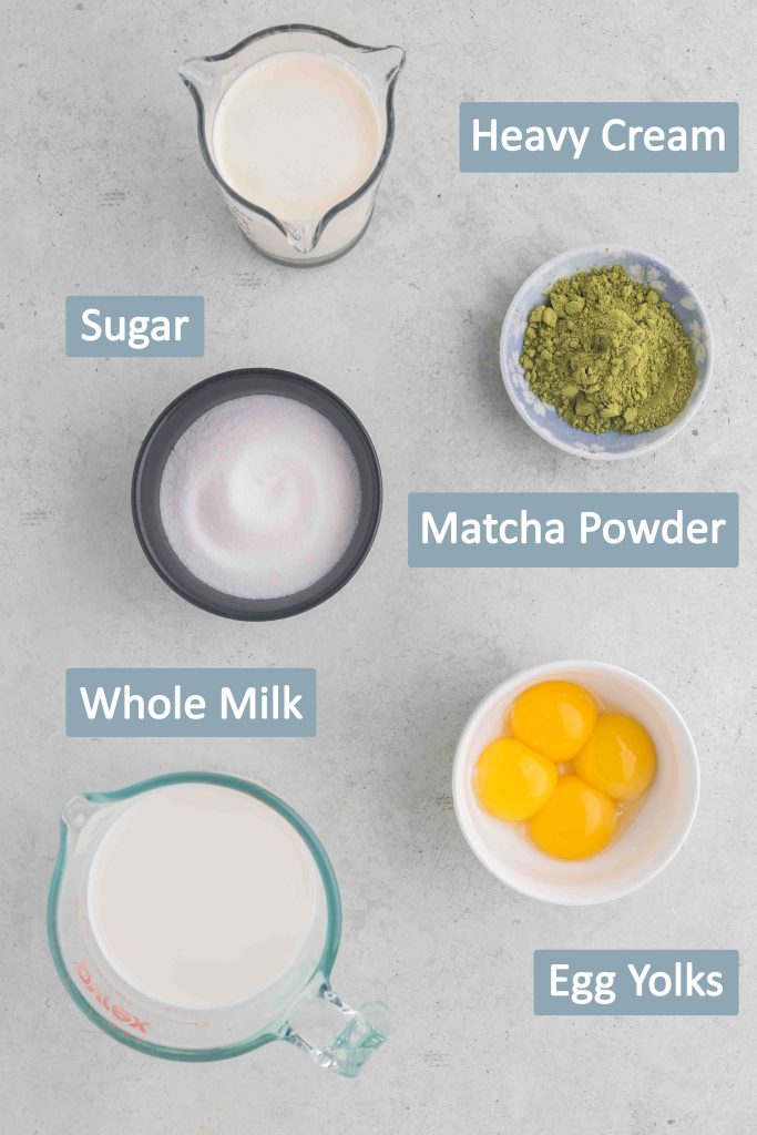 Overhead shot of ingredients needed to make matcha ice cream. Ingredients include whole milk, heavy cream, sugar, matcha powder, and egg yolks