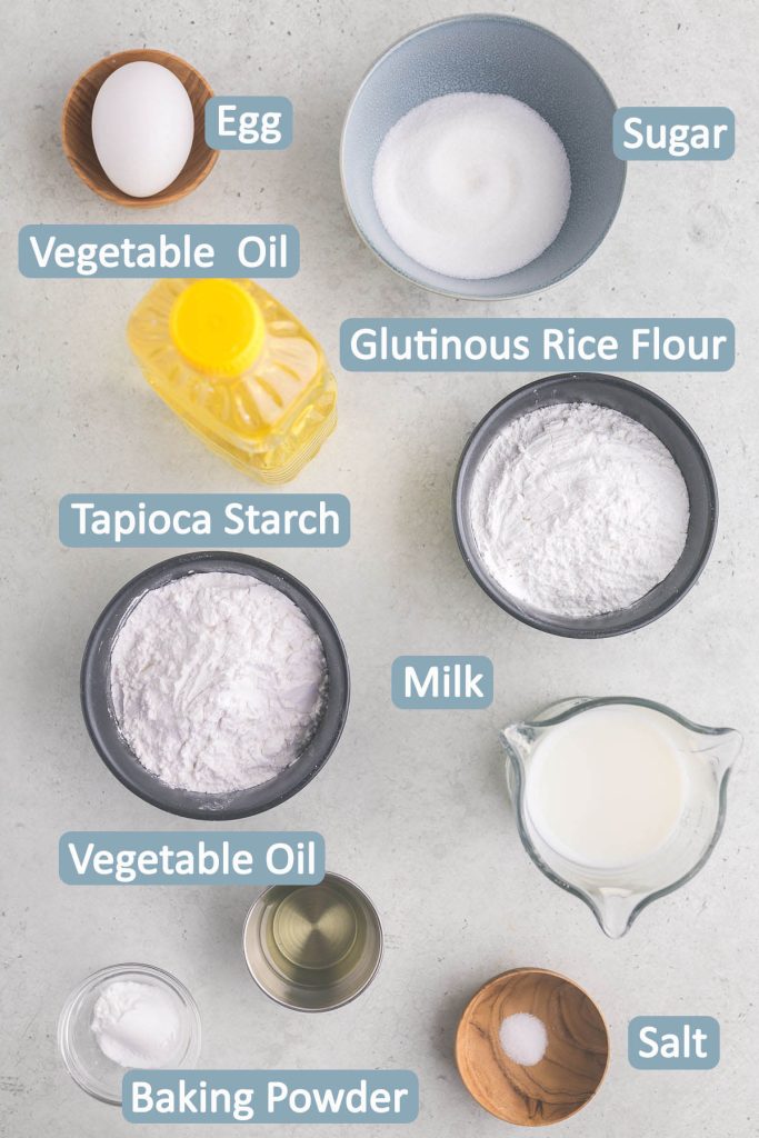 Overhead shot of ingredients necessary to make the mochi donut dough.  Ingredients include: egg, sugar, vegetable oil, glutinous rice flour, tapioca flour, milk, baking powder, and salt