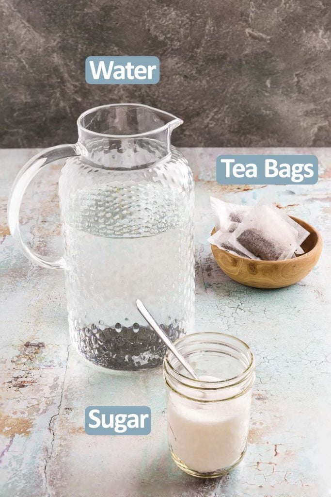 Side shot of the ingredients used to make Cold Brew Tea. Ingredients are: Water, Tea Bags, and sugar