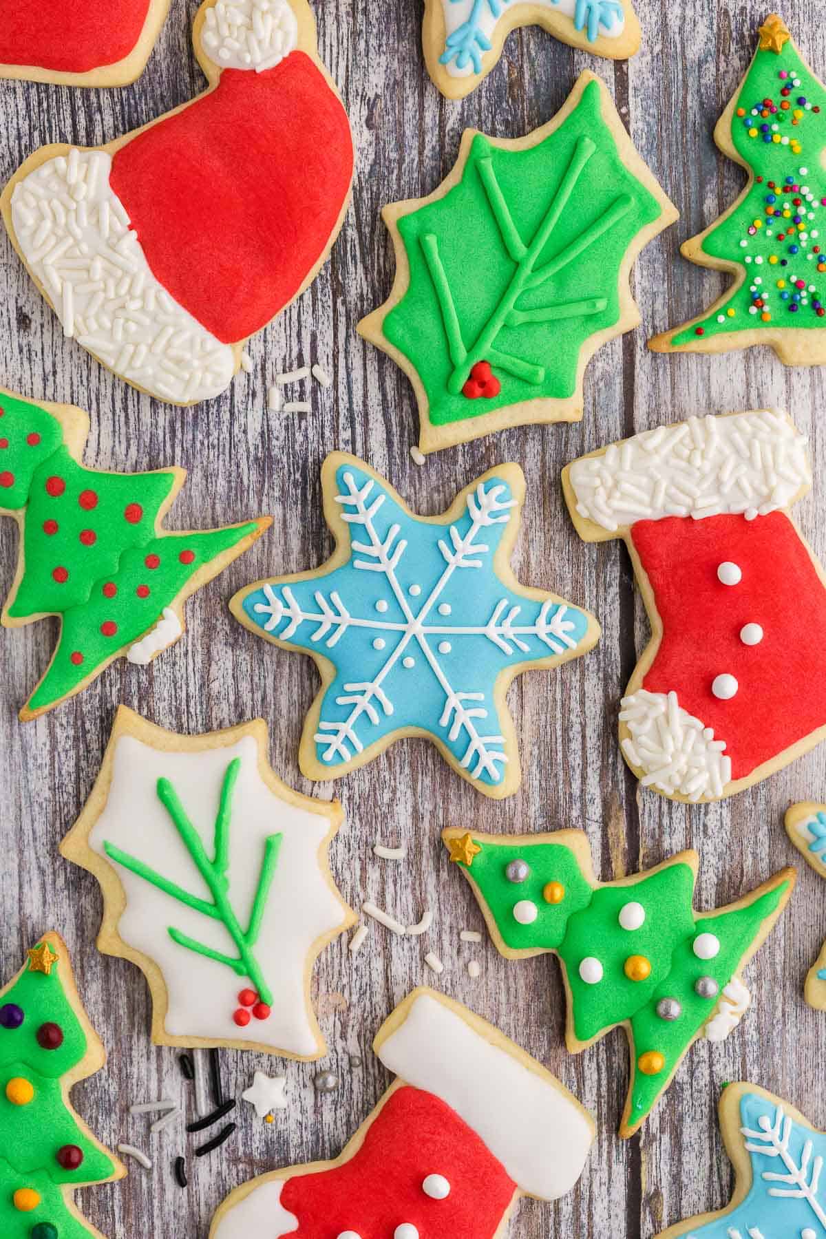 Various festive shaped xmas cookies on a wooden table.