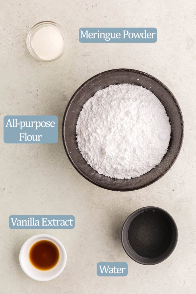 Overhead shot of the ingredients needed to make this royal icing recipe. Ingredients include: confectioners sugar, meringue powder, vanilla extract, and water. Food coloring is optional.