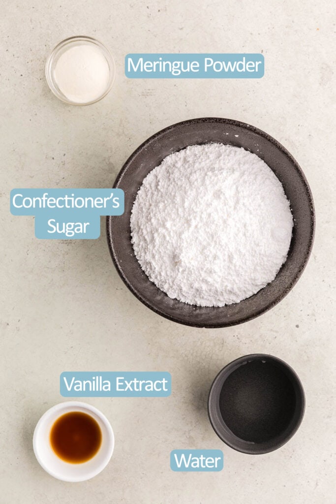 Overhead shot of the ingredients needed to make this royal icing recipe.  Ingredients include: confectioners sugar, meringue powder, vanilla extract, and water.  Food coloring is optional.