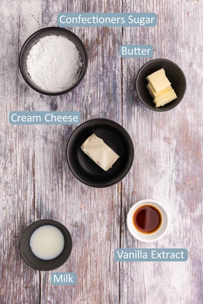 Overhead shot of the ingredients used to make the cream cheese frosting or drizzle for red velvet brownies.  Ingredients include, confectioners sugar, butter, cream cheese, vanilla extract, and milk.