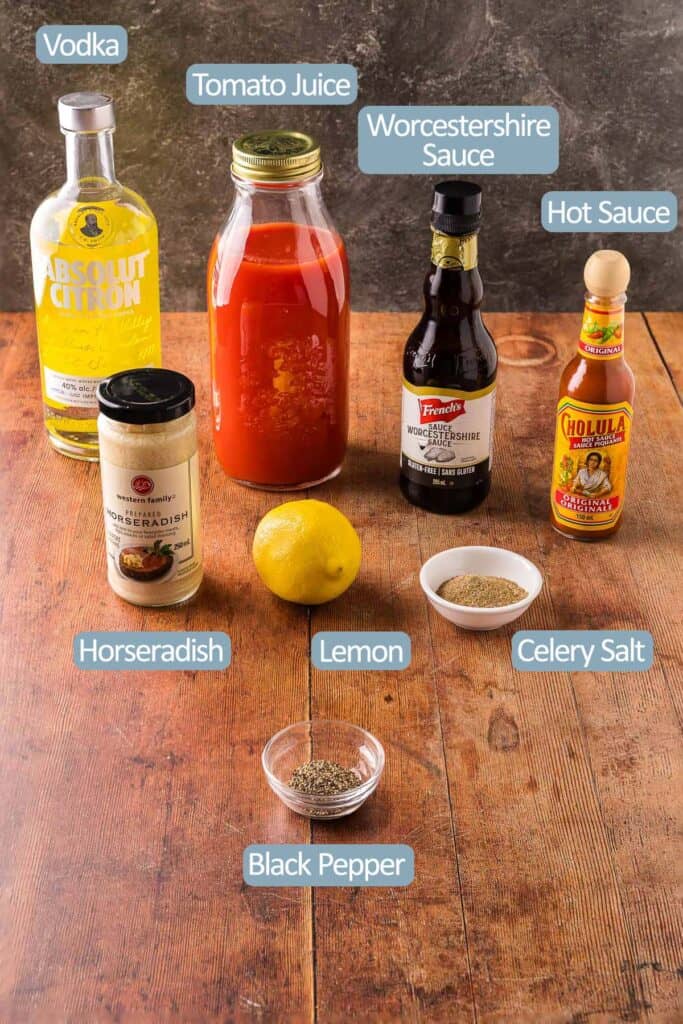 Side shot of the ingredients used to make a Bloody Mary.  Vodka, tomato juice, Worcestershire sauce, hot sauce, horseradish, lemon, celery salt, black pepper.