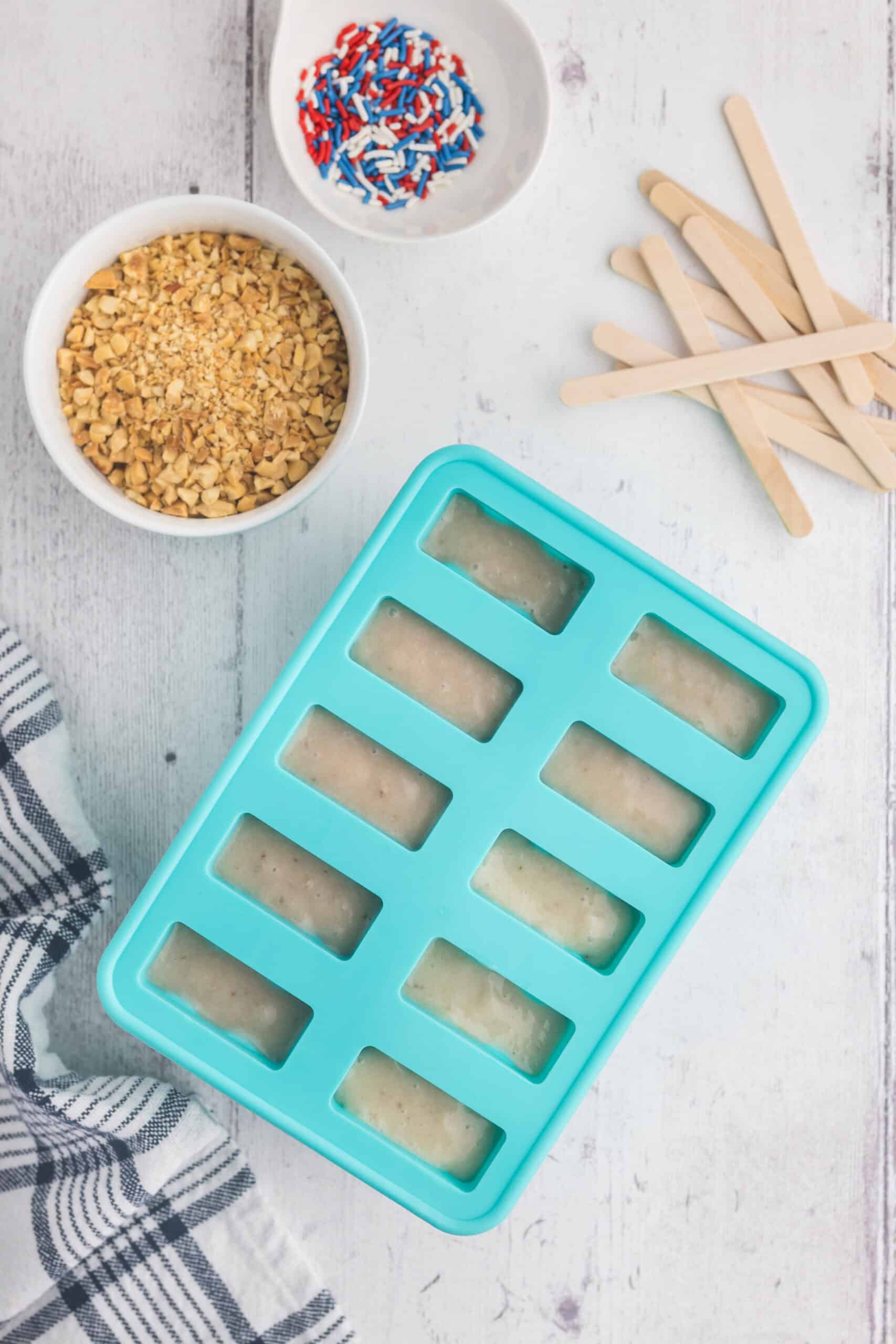 overhead shot of a popsicle mold with the banana mixture added in to each slot.