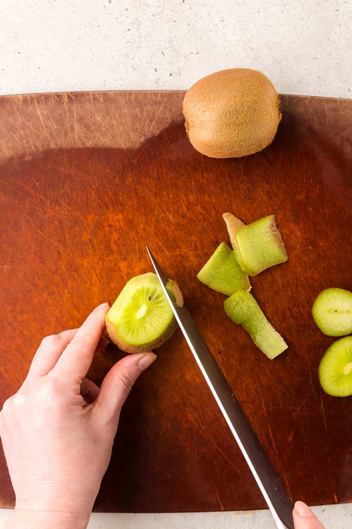Overhead shot of a kiwi having the skin removed.