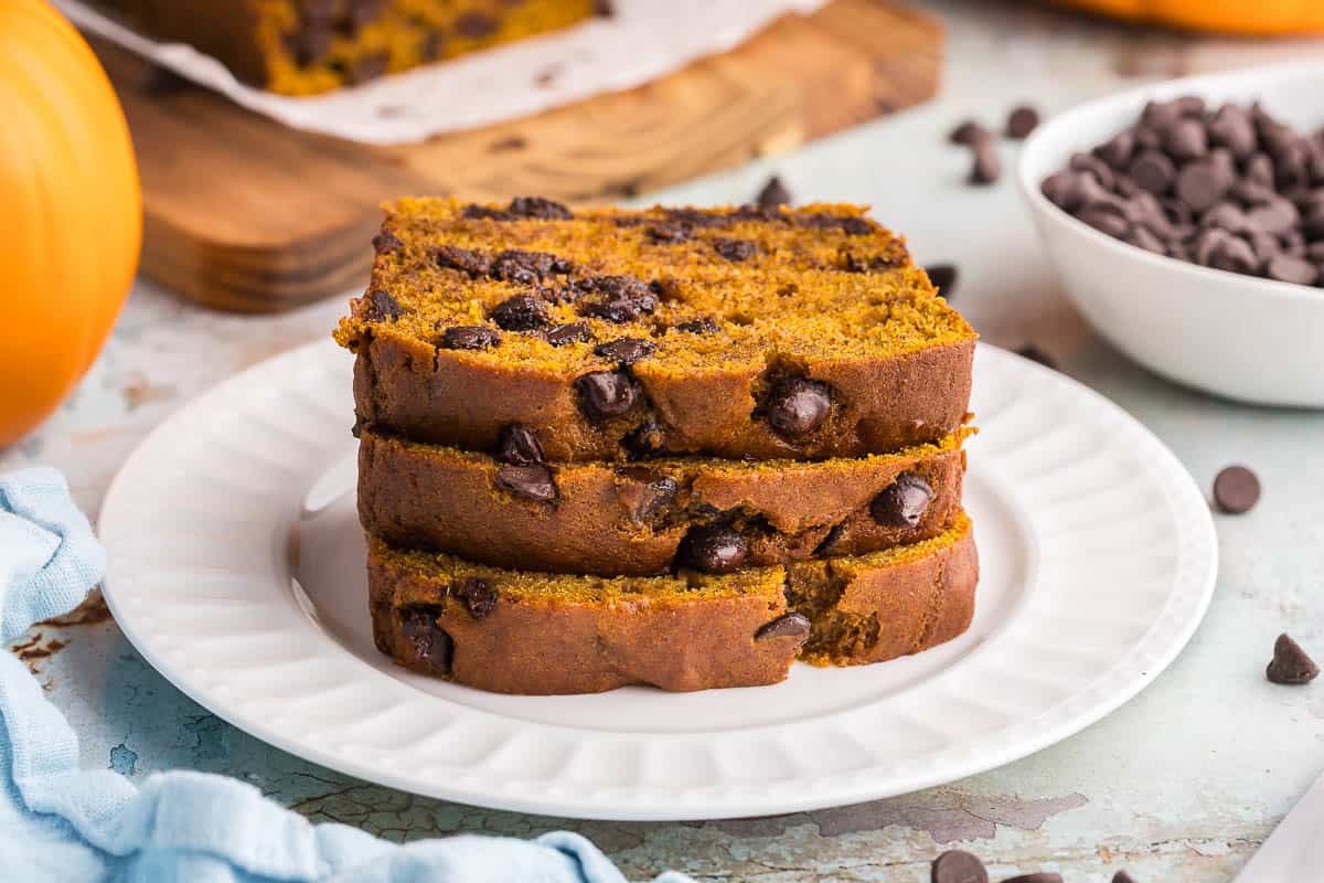 side shot of three slices of pumpkin chocolate chip bread stacked on top of each other.