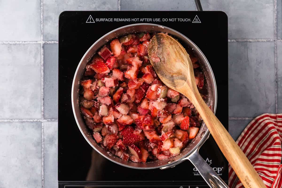 overhead shot of a saucepan filled with all the jam ingredients and beginning to heat it up.