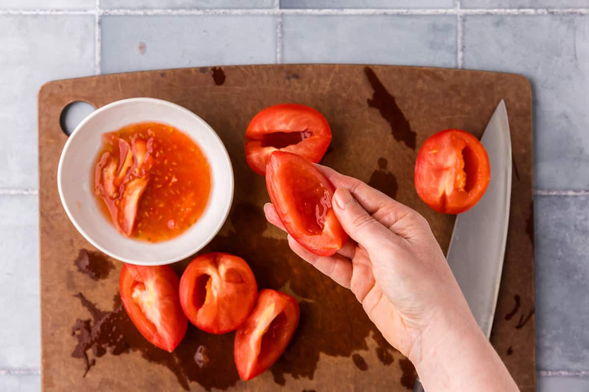 overhead shot showing deseeded tomatoes on a cutting board.